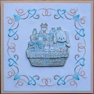 Kaart geboorte, borduur, blauw/bruin/oranje, plaatje mandje met babyproducten, beertje en giraffe 3D
