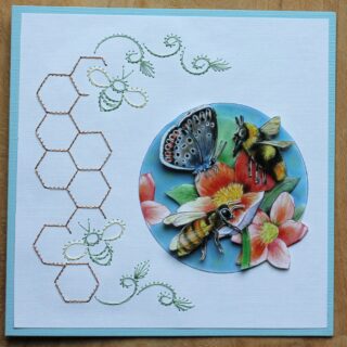 Borduurkaart blauw/wit, plaatje met bloemen, vlinder en bijen in blauwe cirkel